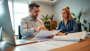 Tax preparer assisting a client in a bright office with financial documents and a laptop.